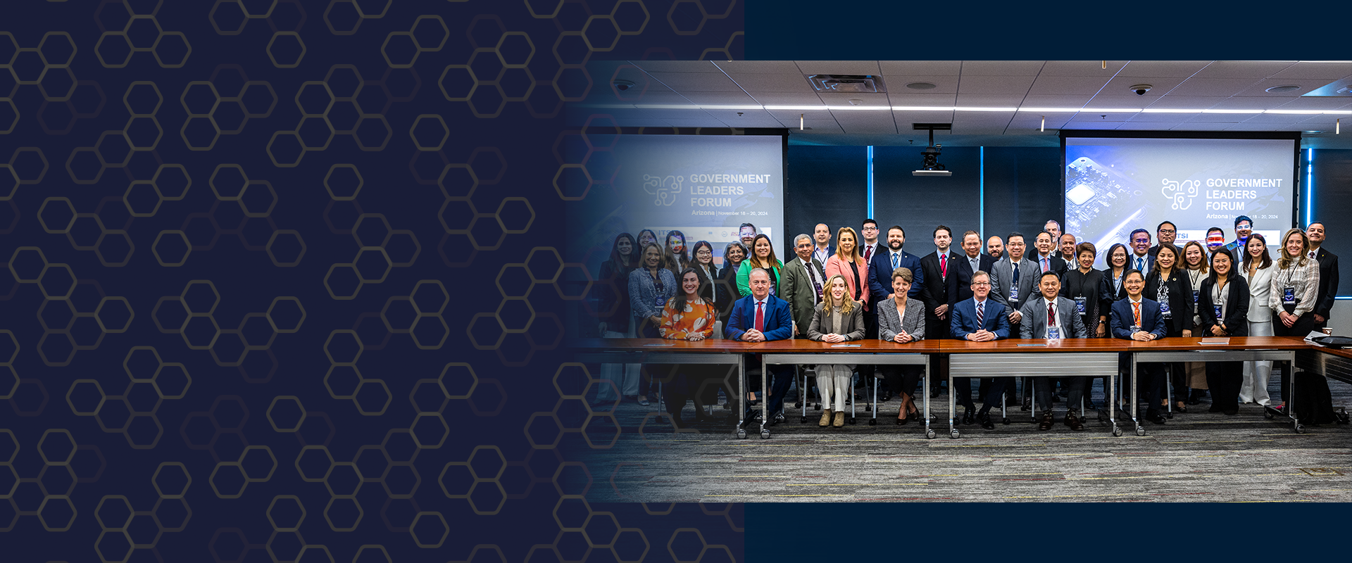 People in a conference room with a large screen displaying graphics and text.